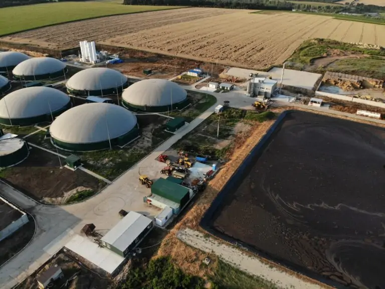 Aerial footage of biogas plant. Aerial view over biogas plant and farm in green fields
